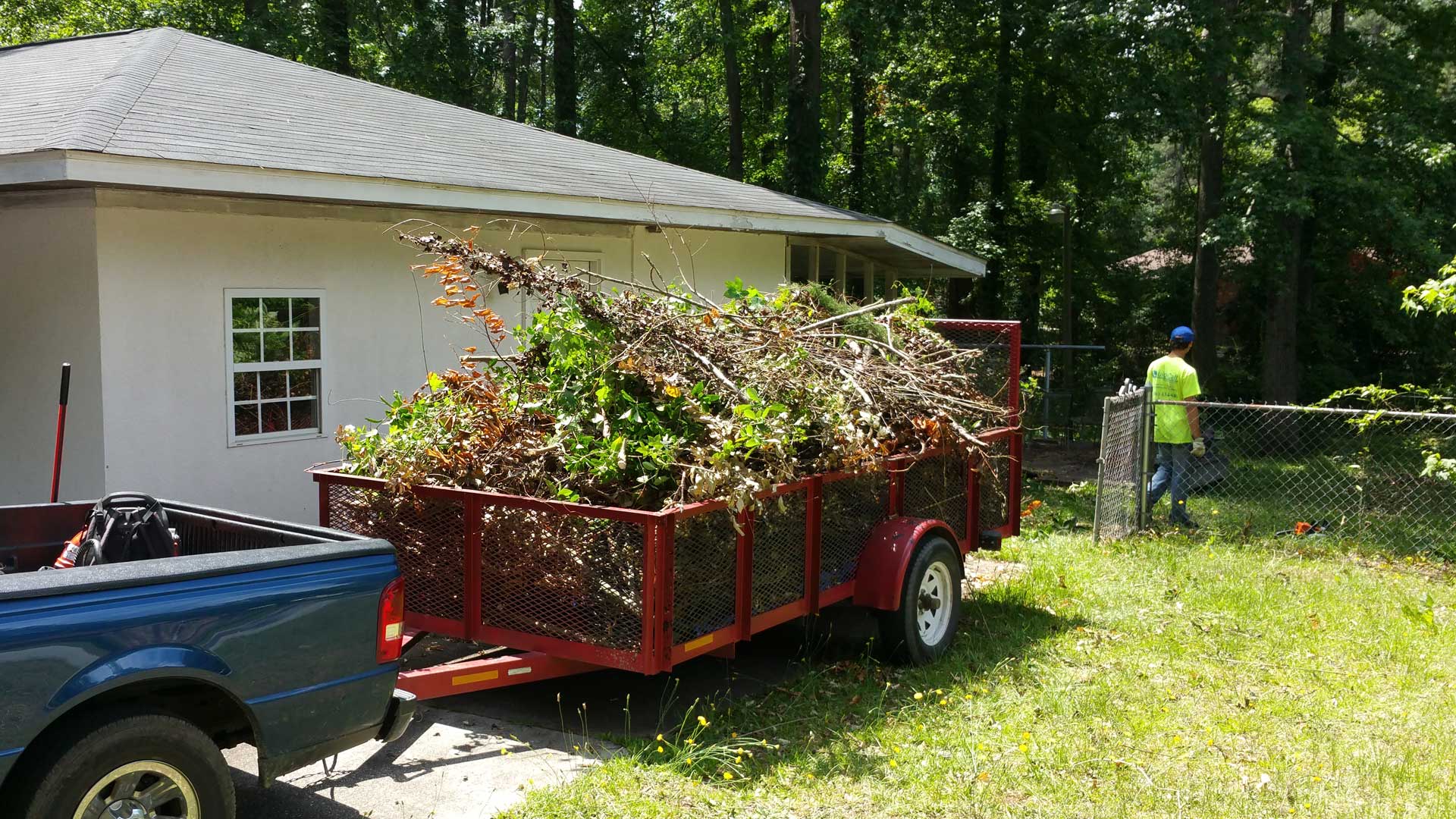 QuickCall Services removing overgrown landscape debris from a home in Martinez, GA.