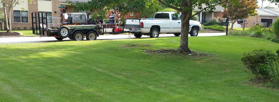 QuickCall Services truck and lawn equipment beside a recently mowed lawn in Grovetown